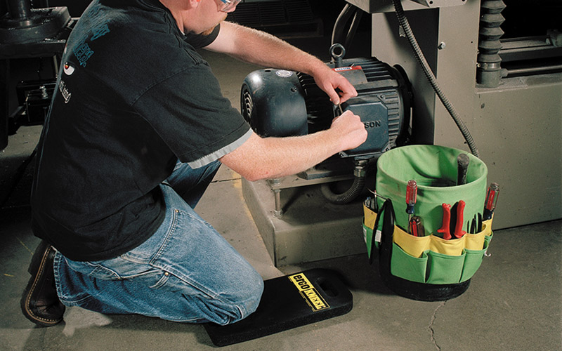 Maintenance worker kneeling on an ErgoKneel mat for comfort