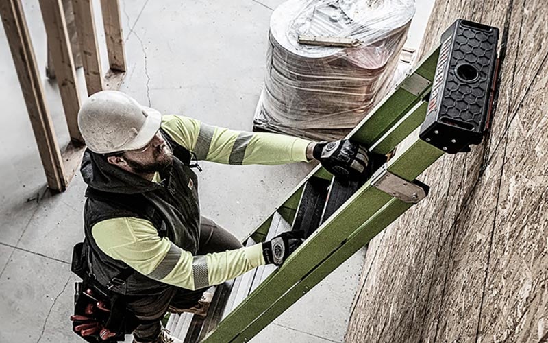 Safe ladder use shown as a worker climbs a well-maintained ladder