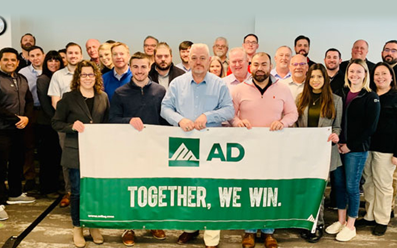 A&M Industrial staff with AD 'Together, We Win' banner after receiving AD Tier One Member of the Year Award in 2021.